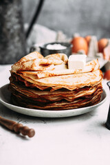 Thin pancakes with butter in a plate