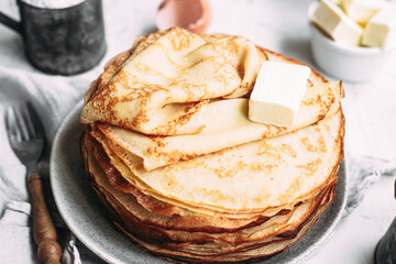Thin pancakes with butter in a plate