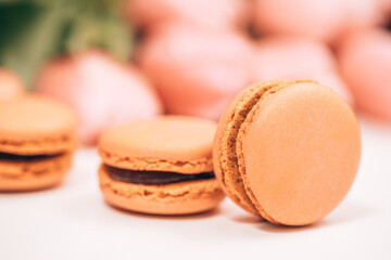 macaroons on table. Yellow macarons with a bouquet of red tulips in the background