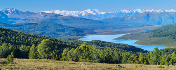 Fototapeta na wymiar Mountain valley with a lake. Snow-capped peaks.