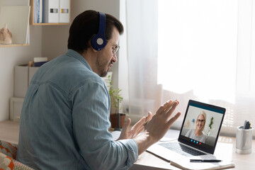 Teleeducation. Focused young man in headset take distant lesson at senior female teacher listen to...