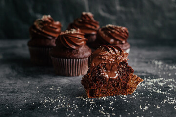 Delicious chocolate cupcakes. Cupcakes on a concrete table. Chocolate biscuit and chocolate ganache