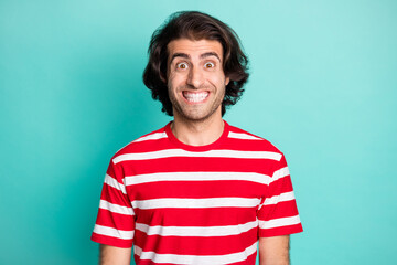 Portrait of nice cheerful funky brown-haired guy smiling sincerely isolated over bright green turquoise color background