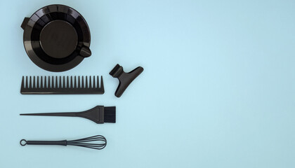 Hairdressing tools for hair dyeing. Hair salon accessories in black on a blue background. Banner with space for text.