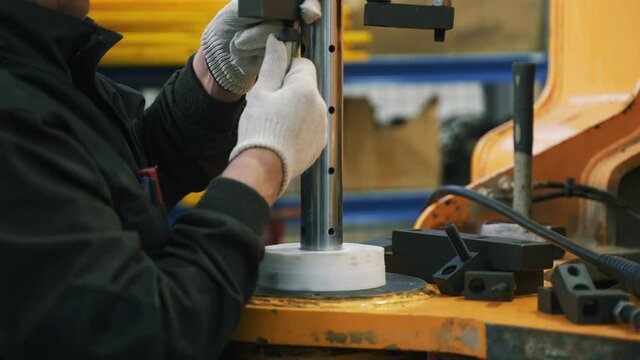 The mechanic tightens the nut. He attaches the boring shaft.