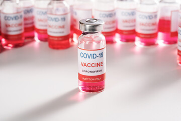 glass vaccine vial for vaccination against COVID-19 SARS-CoV-2 coronavirus pandemic on white background