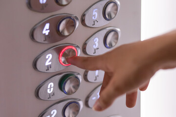 Finger of a woman's hand pressing an elevator button