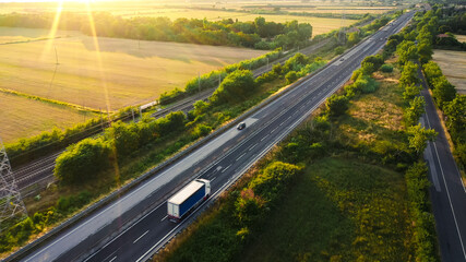 Aerial Drone Shot: Long Haul Semi Trucks Driving on the Busy Highway in the Rural Region of Italy....
