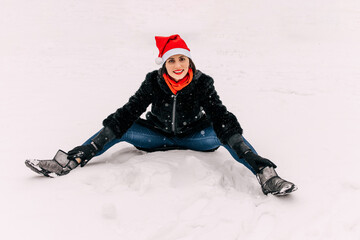 Naklejka premium happy woman in Christmas hat smiling in snowy winter forest, spending christmas vacation outside. Outdoor seasonal activities. Lifestyle capture.
