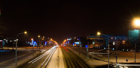 Fototapeta na wymiar Winter night road in city, snow background