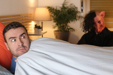 Terrified man seeing a monster in his bedroom