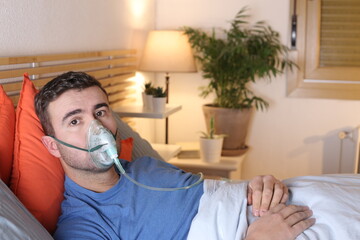 Man using breathing mask in bed
