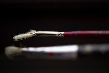 Naklejka premium Used oil paint brushes illuminated by daylight filtering through the window. close up.