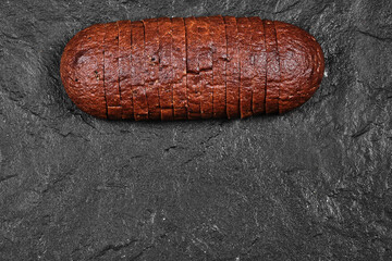 Sliced black bread on dark background