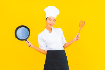 Naklejka premium Portrait beautiful young asian chef woman with black pan