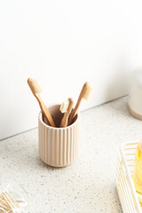 Cup with bamboo toothbrushes in bathroom
