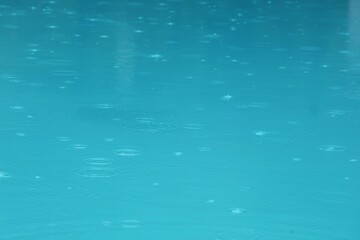 Swimming pool with water drops and reflection in the water in rainy day. Sport and background concept.