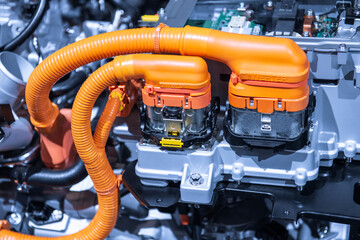 Chassis of the electric car with powertrain and power connections closeup. Blue toned. EV car drivetrain at maintenance.