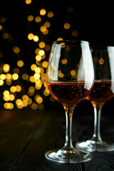 Two glasses of sparkling wine or champagne to celebrate Party or Anniversary with a yellow bokeh effect on dark background. 