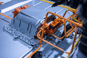 Chassis of the electric car with powertrain and power connections closeup. Blue toned. EV car...