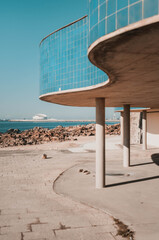 beach volleyball net. Concrete structure with blue tiles. Behind the ocean.