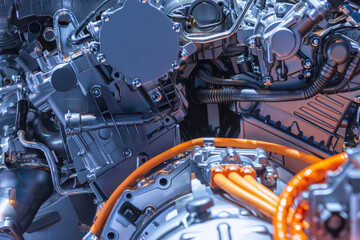 Chassis of the electric car with powertrain and power connections closeup. Blue toned. EV car drivetrain at maintenance.