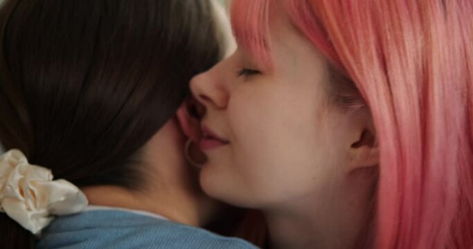 Loving female gay couple kissing and embracing at home