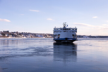 Naklejka premium The ferry across the St. Lawrence River arriving at Quebec City from Levis during a cold clear winter afternoon, Quebec, Canada