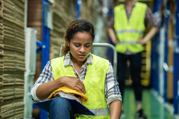 Young African female warehouse worker staff feeling sad and upset while sitting on the floor of the storehouse due to been fired from job cause by company bankruptcy from coronavirus pandemic.