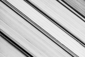 Book cover background. Books stack closeup texture. Black and white photo.