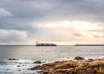 Naklejka premium West coast of the Atlantic ocean coast with a cargo ship on the horizon in Porto, Portugal