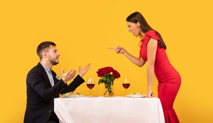 Couple Having Quarrel During Romantic Date On Yellow Studio Background