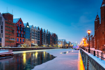 Obraz premium Granaries island over Motlawa river in snowy night, Gdansk. Poland