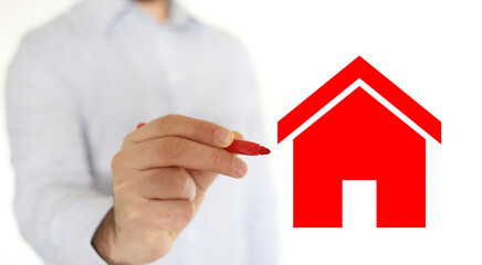 Hand of man drawing a red house on a glass.  Investment Concept of buy or sell house.