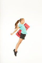 Cute sporty girl holding yoga mat and jumping