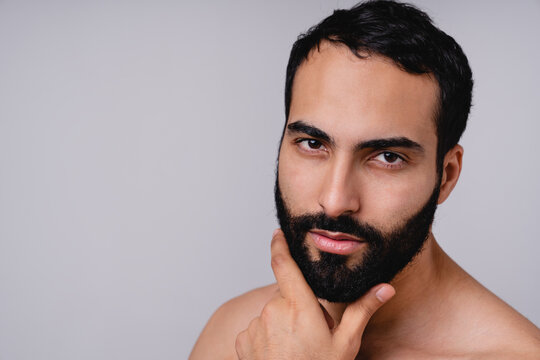 Close up portrait of an attractive moroccan man with beard isolated over grey background
