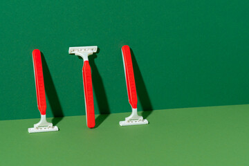 Disposable razor on green background, studio shot