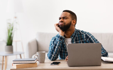 Frustrated Black Businessman Sitting At Laptop Bored Of Work Indoors