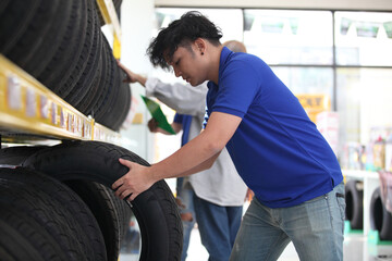 Salesman with showing wheel tires at car repair service or auto store, business, maintenance and people concept