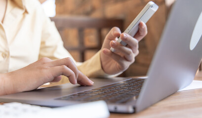 Finance workers are reviewing the company's financial data on a laptop and using smartphones to communicate or chat with the team at social distances, Working during the virus outbreak.