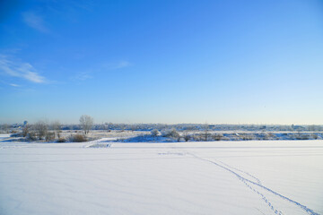 Fototapeta na wymiar Winter landscape. Snow-covered lake in the distance is beautiful forest and beautiful fblue sky