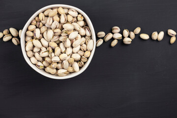 food frame composition of pistachios on black background