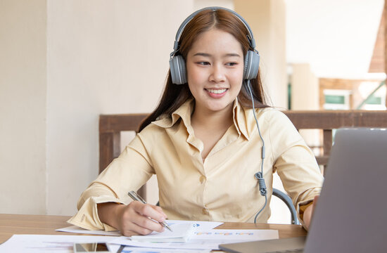 Asian woman is studying online via the internet with a cheerful smile, stay home, New normal, Covid-19 coronavirus, Social distancing, Internet learning.