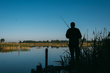 Man fishing on sunset. Men's hobby concept.