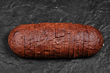 Sliced black bread on dark background
