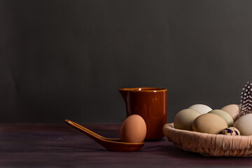 Easter photo concept. Egg, spoon and pitcher. Low key. Free space