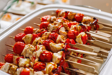 Delicious roasted turkey or chicken kebab skewers meat barbecue on clay dish with tomatoes.