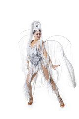 Obraz na płótnie Canvas Graceful. Beautiful young woman in carnival, stylish masquerade costume with feathers dancing on white studio background. Concept of holidays celebration, festive time, dance, party, fashion