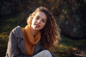 Portrait of attractive stylish girl looking at camera  Beautiful curly haired woman