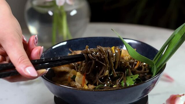 Japanese food: Stir-fried soba noodles and vegetables in black bowl. Delicious, nutritious Asian food